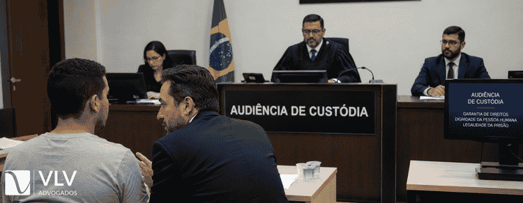 Audiência de Custódia: quais as chances reais de soltura? 1 homem com seu advogado em tribunal brasileiro para audiência de custódia