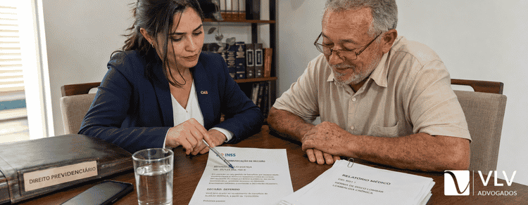 Advogada explica carta de indeferimento do INSS a idoso durante atendimento sobre BPC LOAS.