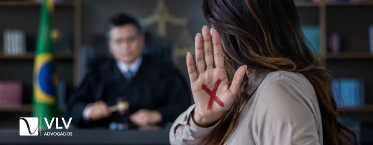 imagem de mulher com um x na mão representando um basta para violência doméstica