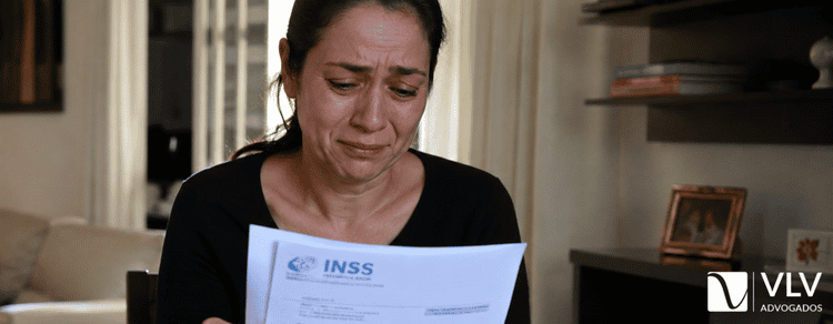União estável dá direito à pensão por morte? Regras e prazos 1 mulher chorando com papéis do INSS na mão pois precisa pedir pensão por morte na união estável
